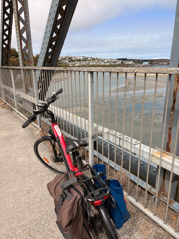 My bike on an old railway bridge with a view of Padstow beyond