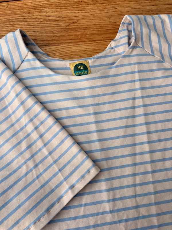 a finished blue/beige stripy t-shirt lying flat on the table