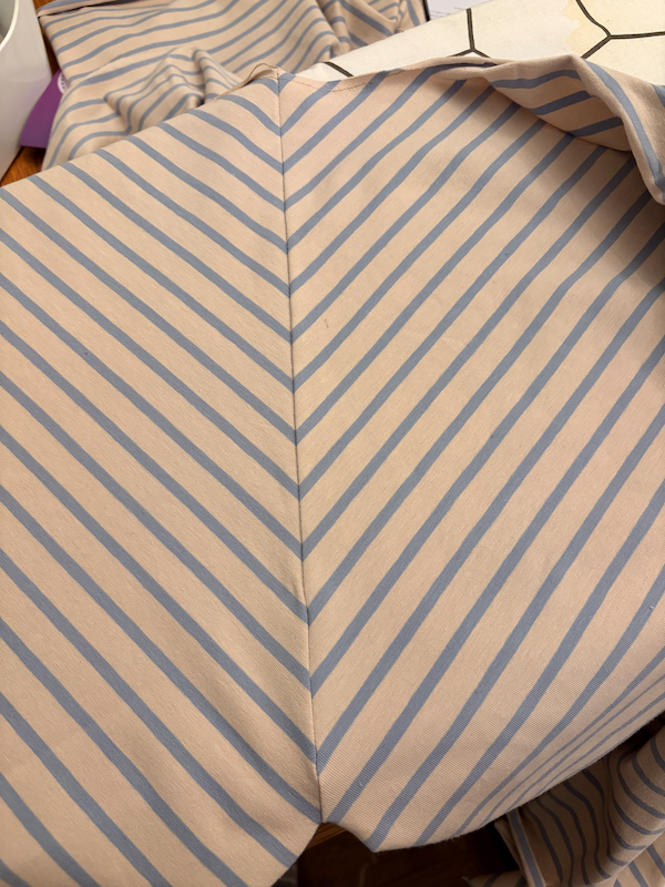 close up of a blue/beige stripy t-shirt under construction with really well matched stripes on a seam